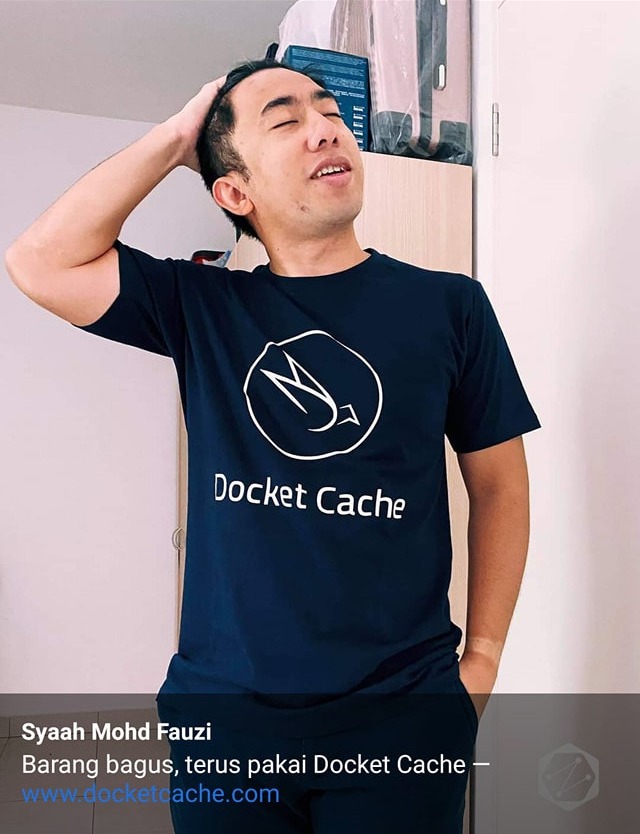 A supporter wearing the navy Docket Cache t-shirt with the white logo, captioned "Barang bagus, terus pakai Docket Cache"